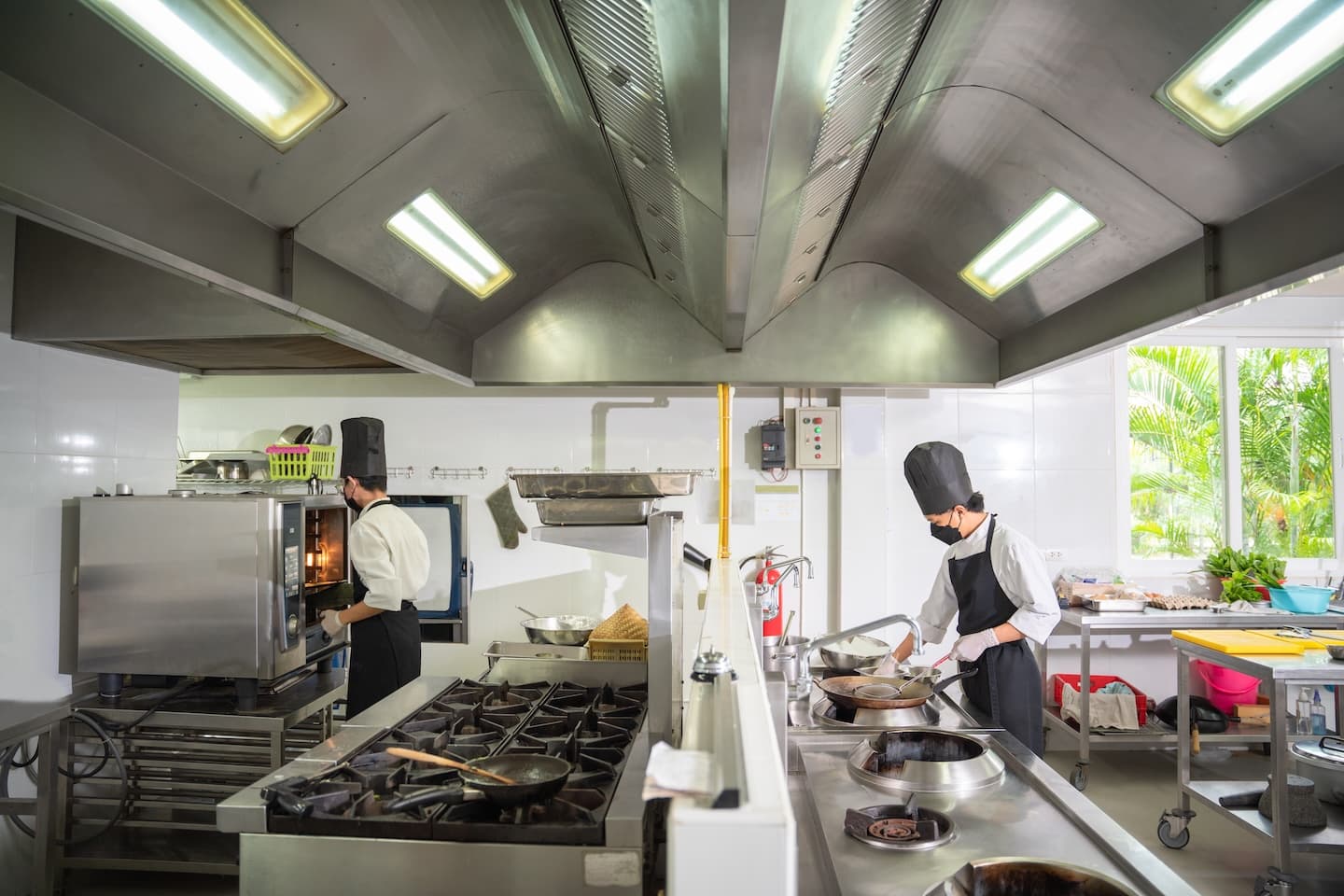 Commercial kitchen with FRP wall panels behind cooking staff 